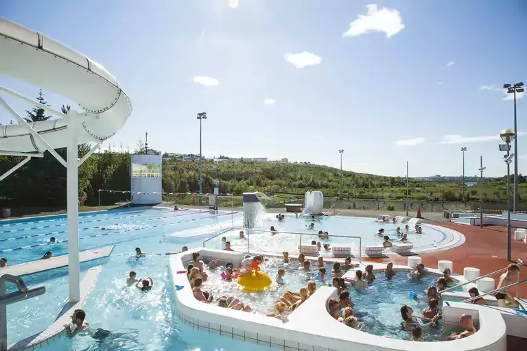Árbæjarlaug swimming pool with people enjoying a sunny day